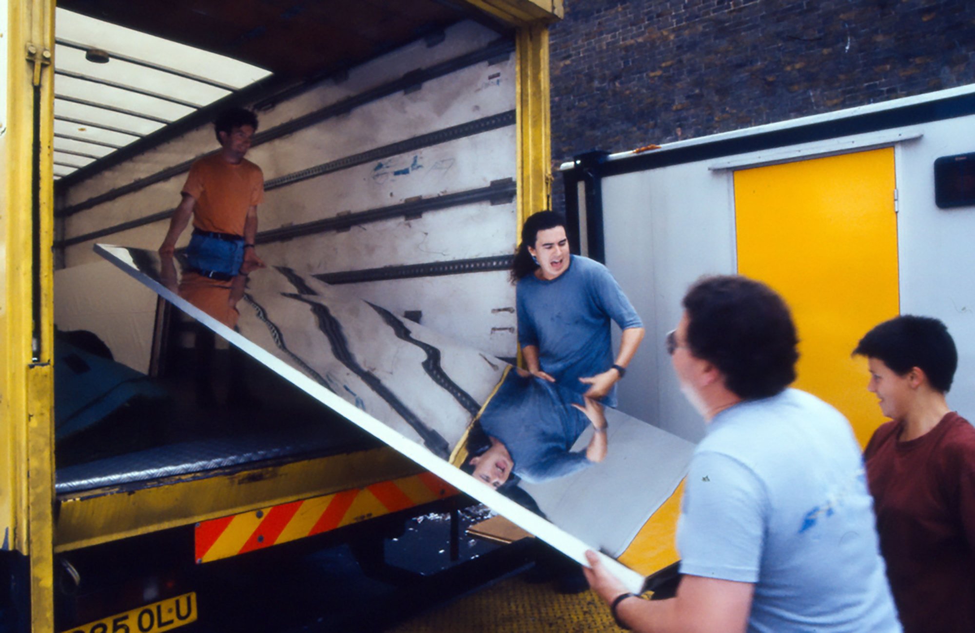Image: Production crew unload one of the mirrors used on stage by the Michael Clark Company performing Mmm... at King's Cross Depot, 1992. Photograph: Stephen White
