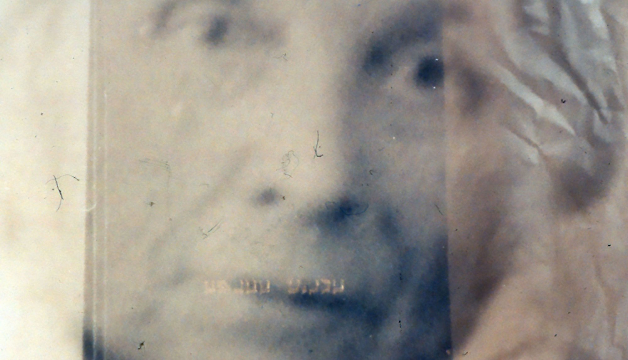 Image: Detail of a black and white portrait of Rodinsky laid on a wrinkled white sheet. Photograph: Rachel Lichtenstein