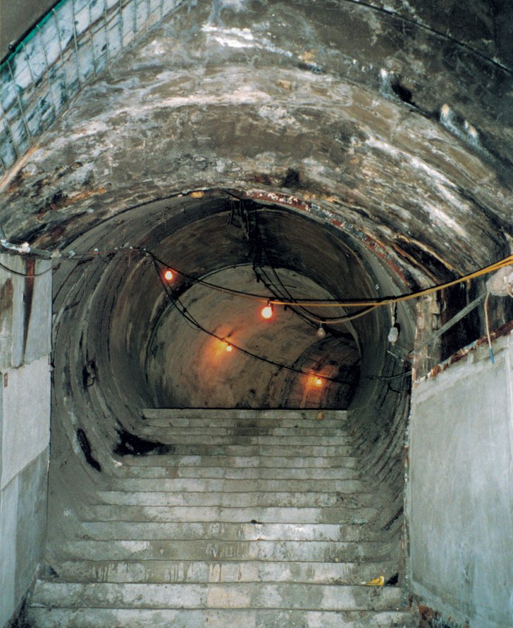Steps in the disused Strand tube station, lit by a string of lights, lead to a tunnel, which curves away into the distance. This was the setting for The Vertical Line (1999) by John Berger and Simon McBurney.