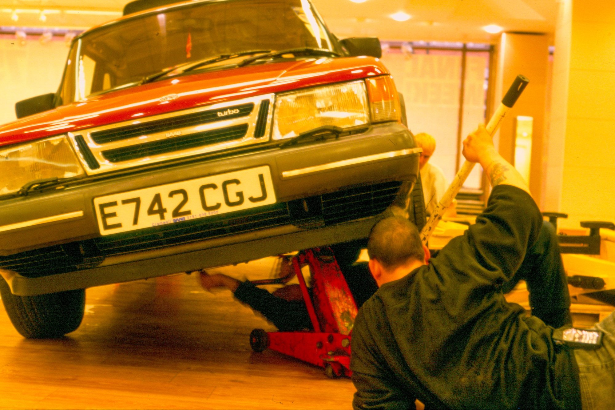 Image: Two of Michael Landy's operatives begin to deconstruct his cherry red Saab situated in the defunct Oxford Street C&A store during Break Down, 2001. Photograph: Parisa Taghizadeh