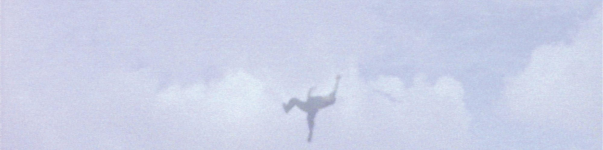 Still from Steve McQueen's Caribs' Leap, 2002 depicting a figure mid-flight against a cloudy sky.
