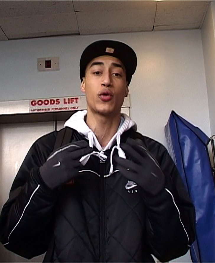 A young man wearing a baseball cap stands in front of a lift. MCs performing for Radio Nights, 2005. Photograph: David Blandy