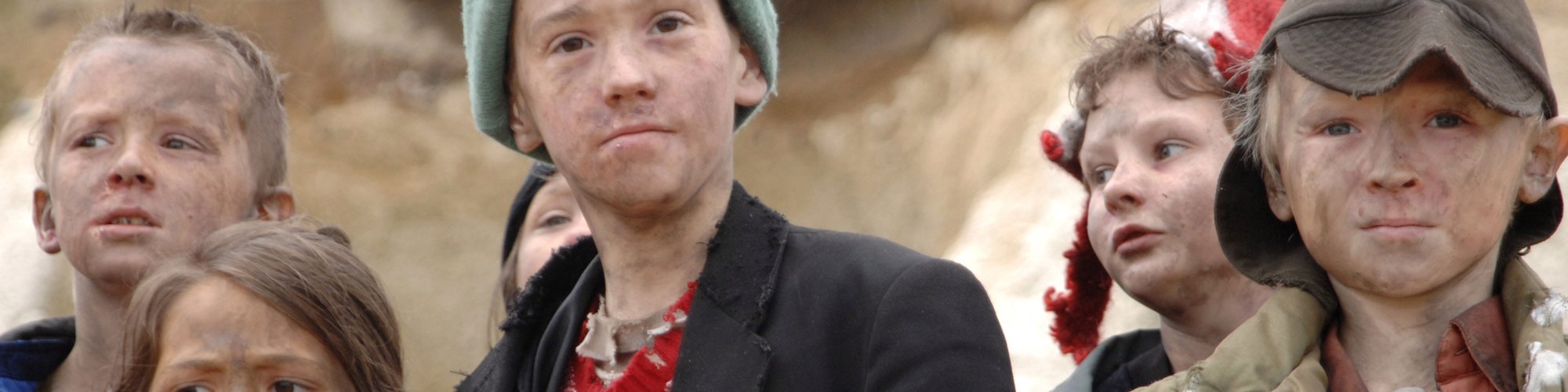 A group of young children with smudges on their faces and dirty clothes look at the camera. Film still from Exodus dir. Penny Woolcock, Margate 2006 
