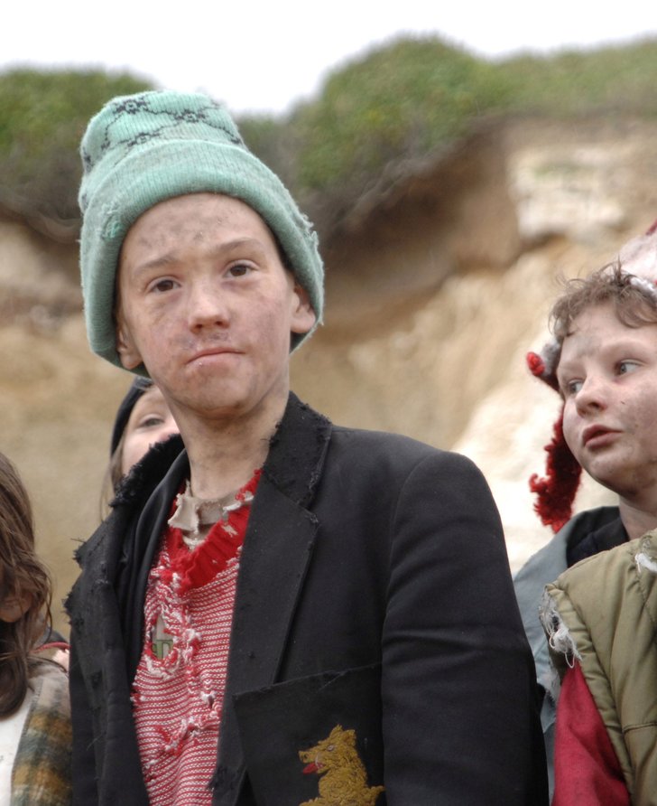 A group of young children with smudges on their faces and dirty clothes look at the camera. Film still from Exodus dir. Penny Woolcock, Margate 2006 