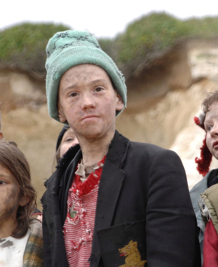 A group of young children with smudges on their faces and dirty clothes look at the camera. Film still from Exodus dir. Penny Woolcock, Margate 2006