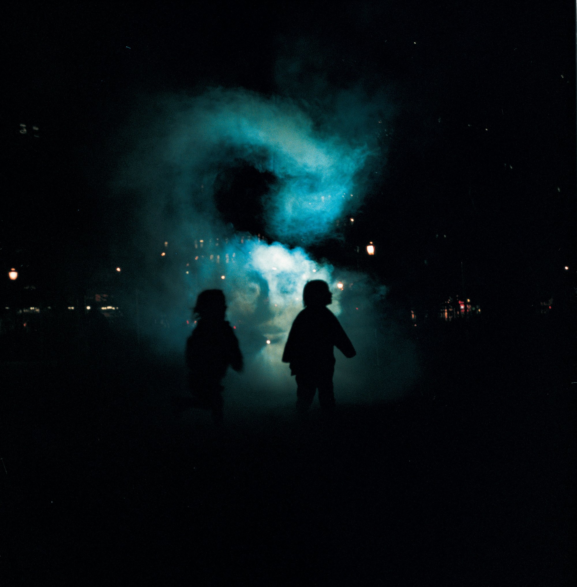 Images: Two young children stand in front of a smoky apparition during The Influence Machine in Soho Square, 2000. Photograph: Dennis Cowley