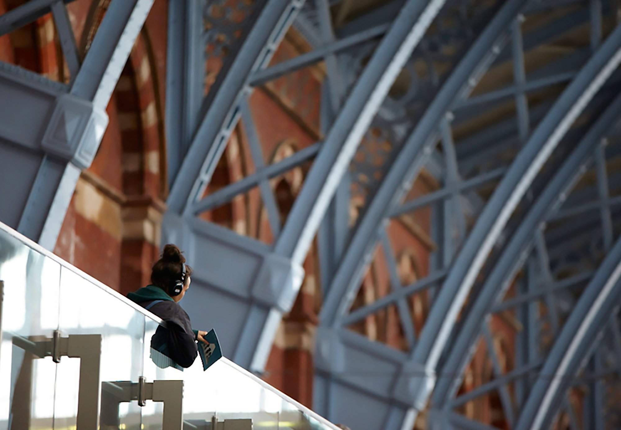 Image: A participant listens to Audio Obscura through headphones on the upper concourse of London St Pancras station, 12 October 2011. Photograph: Julian Abrams