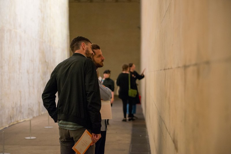 Visitors examining Westminster Hall's east wall from which The Ethics of Dust (2016) was cast. Photograph: William Eckersley