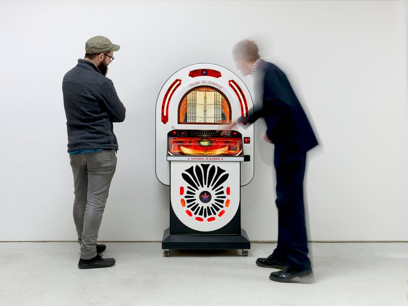 People interacting with Susan Hiller's customised jukebox with 70 songs selected by the artist, London Jukebox, 2008-2018. Photograph: Todd White
