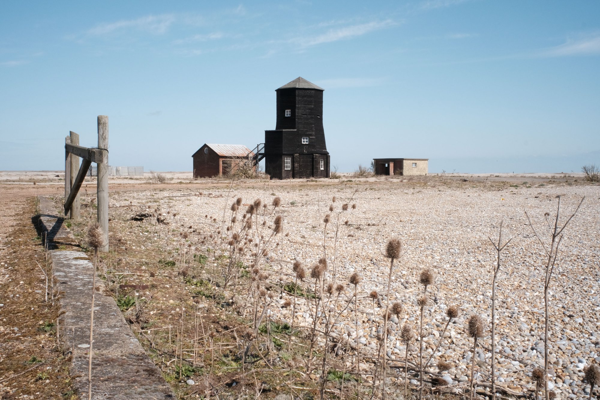 Image:  Black Beacon, Power House and the Shelter from a distance on Orford Ness, April 2021. Part of Afterness, Artangel on Orford Ness in partnership with the National Trust. Photograph: Johny Pitts. 