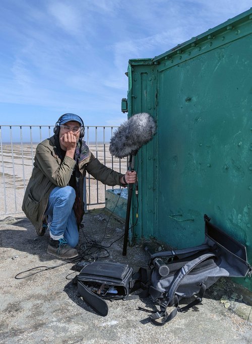 Brian d'Souza recording sound on Orford Ness, 2021. Photograph: Dan Spinney